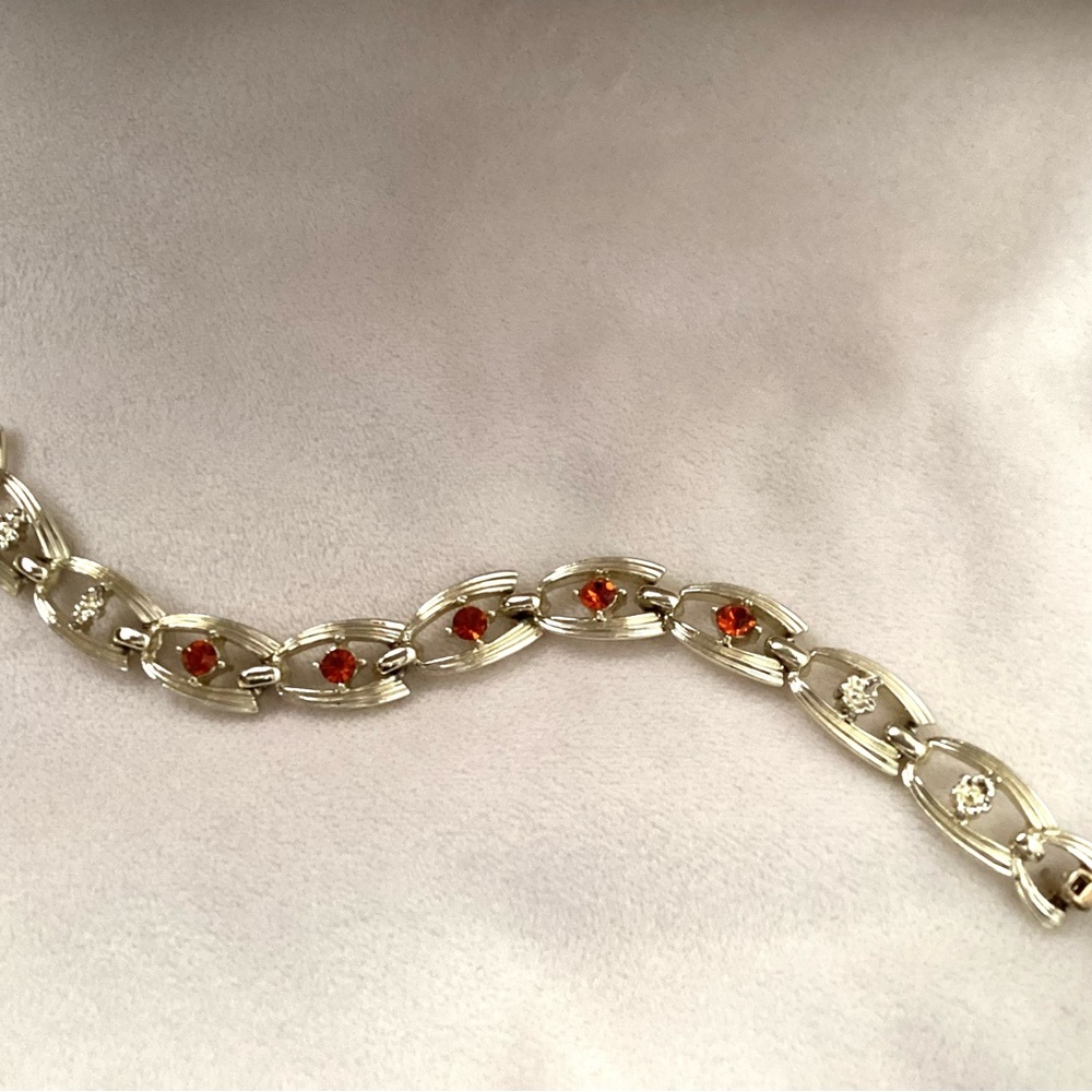 FROM 1950s UNIQUE GOLD-COLORED BRACELET intricate links and red-orange stones.